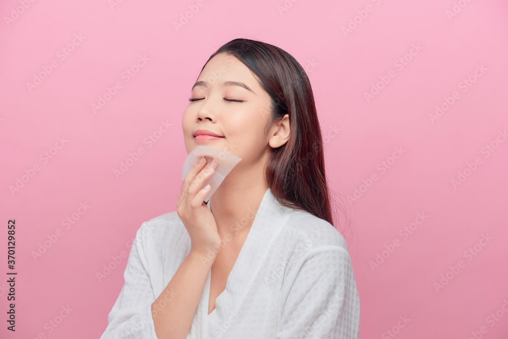 Face skin care. Smiling woman using facial oil blotting paper portrait. Face skin care. Smiling woman using facial oil blotting paper portrait.