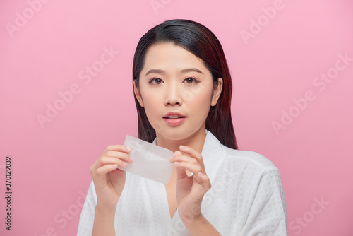 Obraz na plátně Young asian skin care woman smile and use oil blotting paper on her face