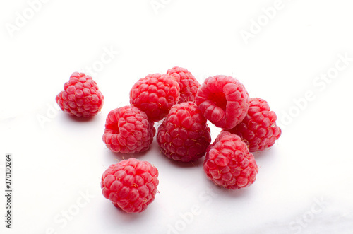Heap of freah rasberries on the white surface