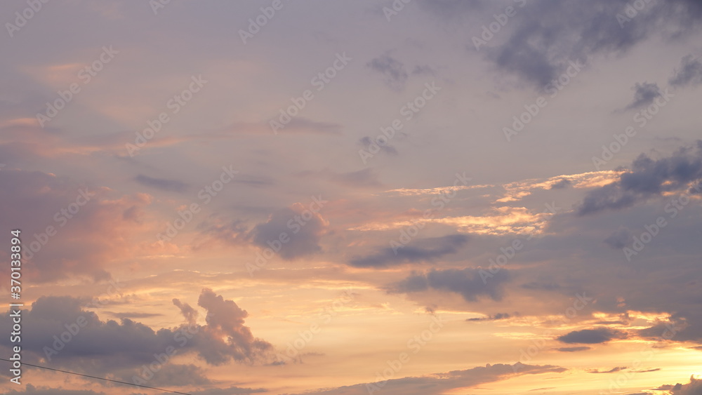 Beautiful evening blue sky at sunset with flaming bright light clouds. A warm summer evening at sunset. Beautiful evening blue sky at sunset with flaming bright light clouds. A warm summer evening at sunset.