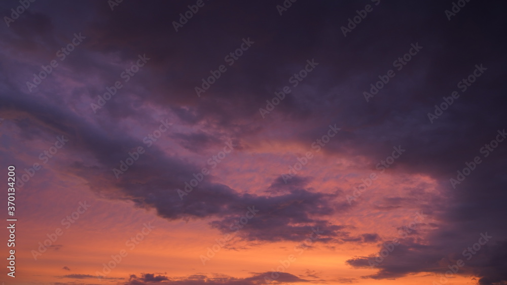 Beautiful evening blue sky at sunset with flaming bright light clouds. A warm summer evening at sunset. Beautiful evening blue sky at sunset with flaming bright light clouds. A warm summer evening at sunset.