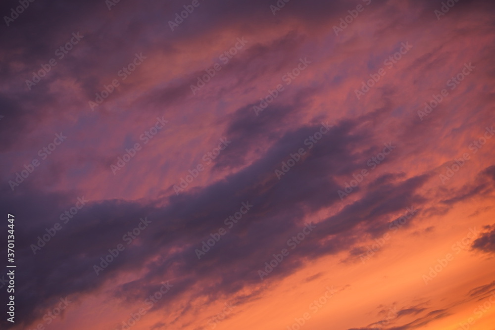 Beautiful evening blue sky at sunset with flaming bright light clouds. A warm summer evening at sunset. Beautiful evening blue sky at sunset with flaming bright light clouds. A warm summer evening at sunset.