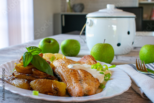 fried salmon fillet with roasted potatoes and tartar sauce on a plate photo