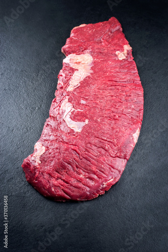 Foto Raw wagyu top butt flap beef steak offered as top view on rustic black board wit