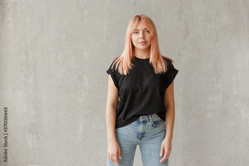 Young girl wearing blank black t-shirt. Concrete wall background. Horizontal Young girl wearing blank black t-shirt. Concrete wall background. Horizontal