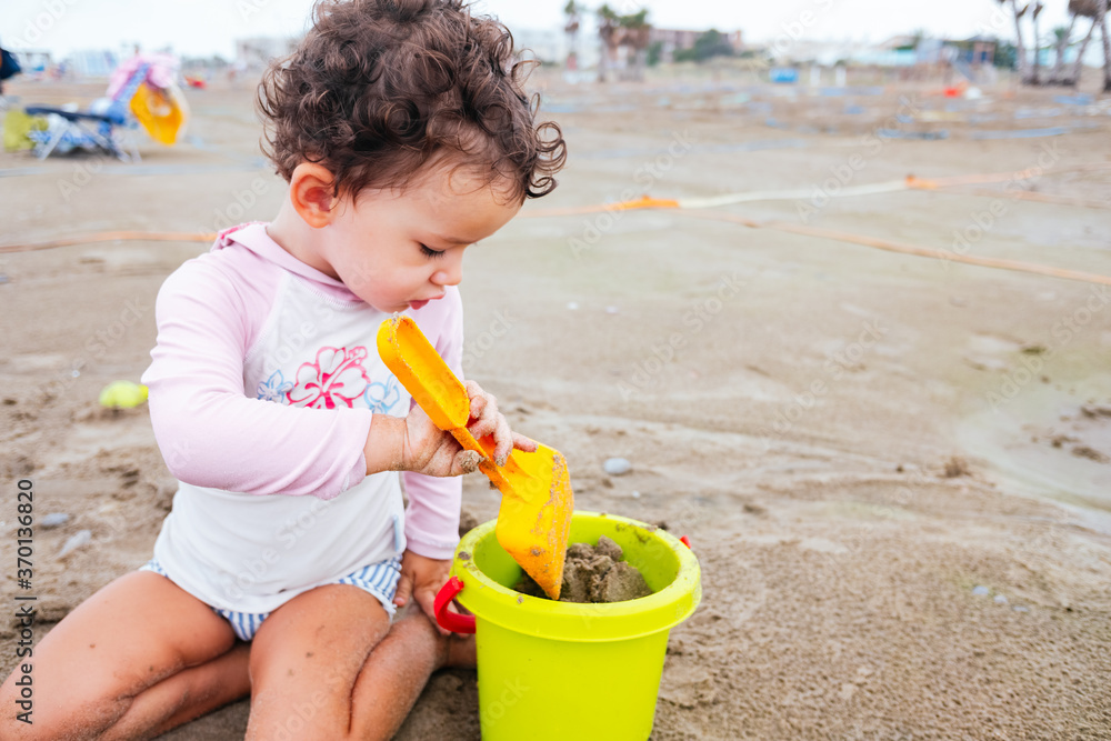 A baby enjoys playing on the beach during the new normality after the pandemic. A baby enjoys playing on the beach during the new normality after the pandemic.