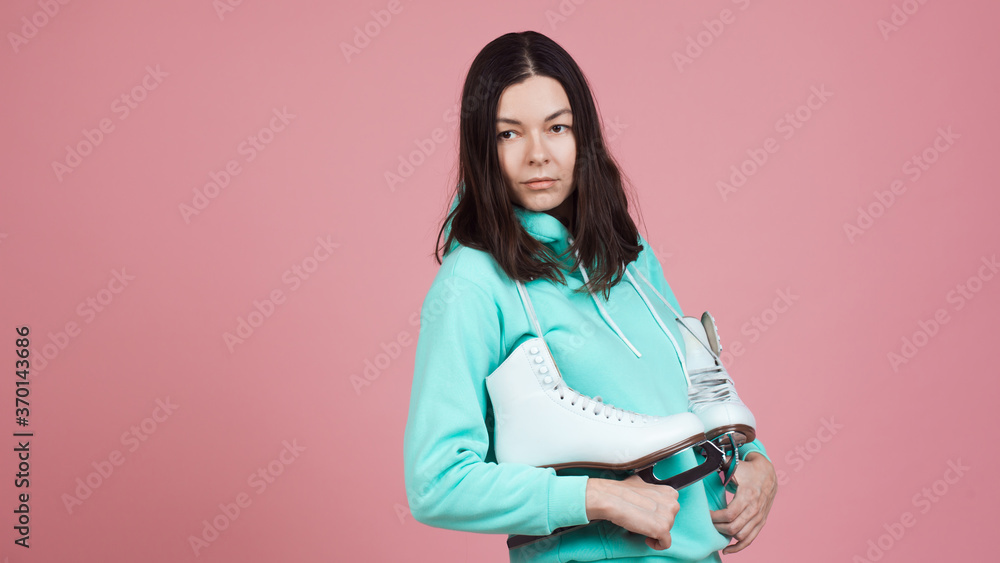 Figure skating for adults, Hobbies and a healthy lifestyle. A young woman in a bright sweatshirt with figure skates Figure skating for adults, Hobbies and a healthy lifestyle. A young woman in a bright sweatshirt with figure skates