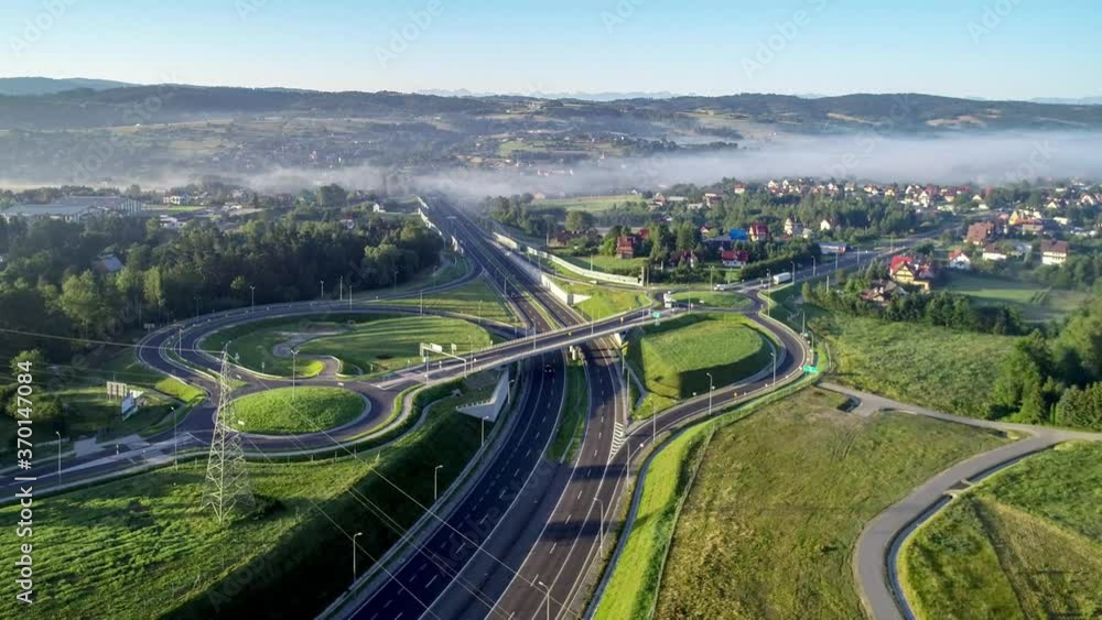 New motorway junction in Poland on national road no 7, E77, called Zakopianka. Overpass crossroad with traffic circles, viaducts and slip roads near Rabka. Aerial video. Far view of Tatra Mountains New motorway junction in Poland on national road no 7, E77, called Zakopianka. Overpass crossroad with traffic circles, viaducts and slip roads near Rabka. Aerial video. Far view of Tatra Mountains