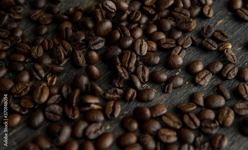 Roasted arabica coffee beans scattered on a wooden table. Fresh coffee beans.