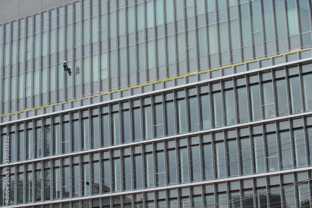 A man cleaning the windows of a building A man cleaning the windows of a building