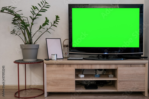 Mockup, green screen TV on the bedside table next to the potted plant