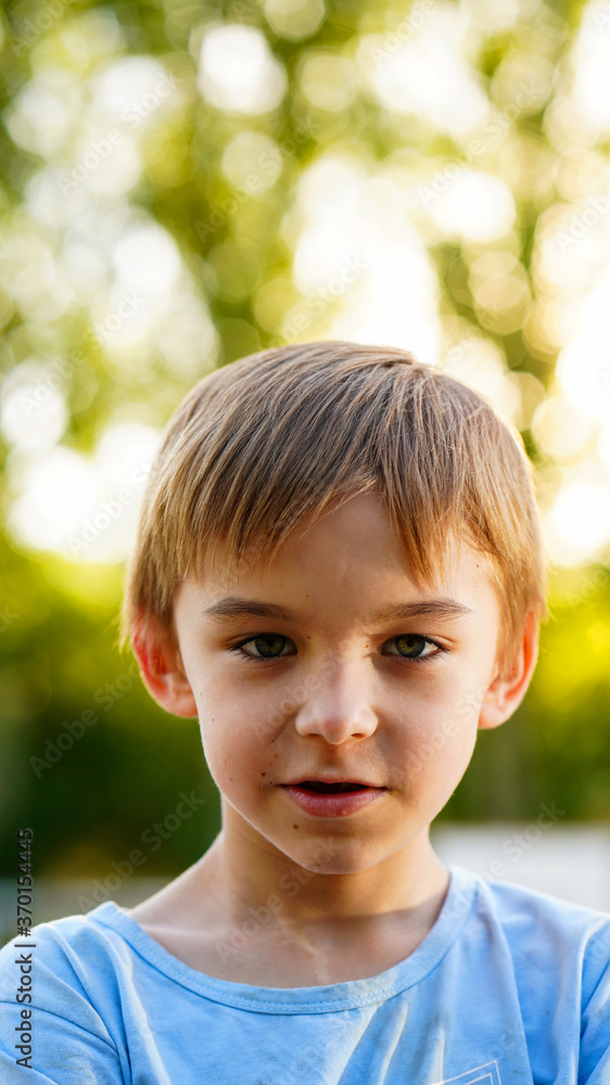 Portrait of little cute boy in blue shirt posing outdoors Portrait of little cute boy in blue shirt posing outdoors