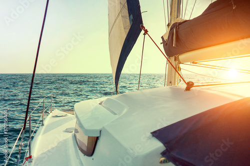 Sailing catamaran at sunset in the sunin the sea high speed in a strong wind during the regatta with sea on the background. Yachting as a luxury sport and great vacation. photo