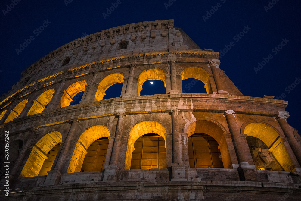 The monumental Colosseum at night, the largest oval Amphitheatre built by the Flavian dynasty in the centre of Rome, just east of the Roman Forum, an iconic symbol of the Roman Empire, Rome, Italy.