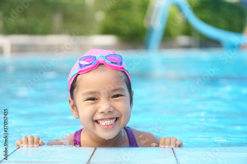 Obraz na plátne Asian child cute or kid girl wear swimming suit and goggles on swimming pool and