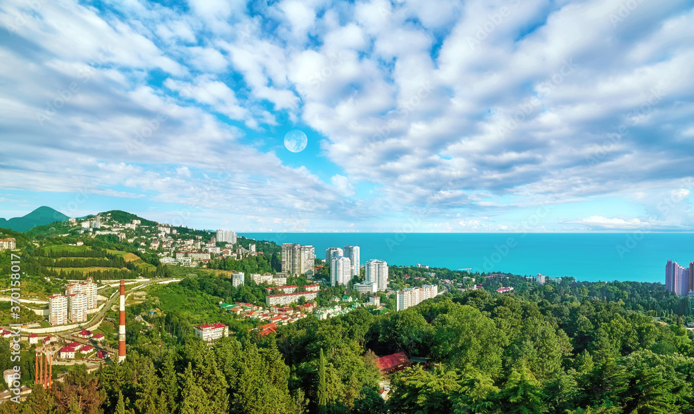 Aerial view of blue coast of Black Sea near  Sochi city with residential houses and recreation area under summer cloudy sky