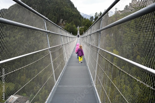 Fototapeta Naklejka Na Ścianę i Meble -  Kühne Stahlkonstruktion über der Fernpassstraße - Die 406 m lange Hängebrücke für Fußgänger  ist im Tibetstil errichtet und kann bis zu 1000 Personen tragen. Ihre Begehung ist kostenpflichtig