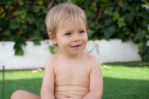 Beautiful blond baby smiling in the garden