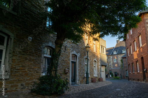 Stolberg, Germany - August 6, 2020: Narrow lane and tree in the old town of Stolberg