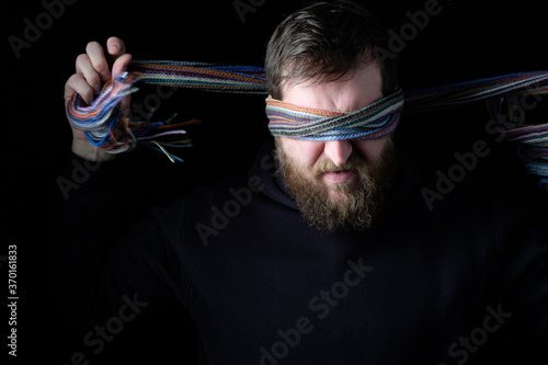 Slika na platnu the man tightly tightens the bandage in front of his eyes so as not to see