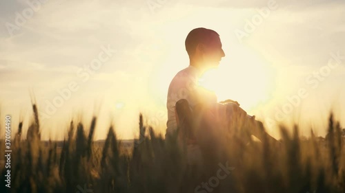 Happy family. A parent is circling, rocking a little girl in the Park at sunset in a large wheat field. The child in the hands of the father as the plane flies, playing the pilot.