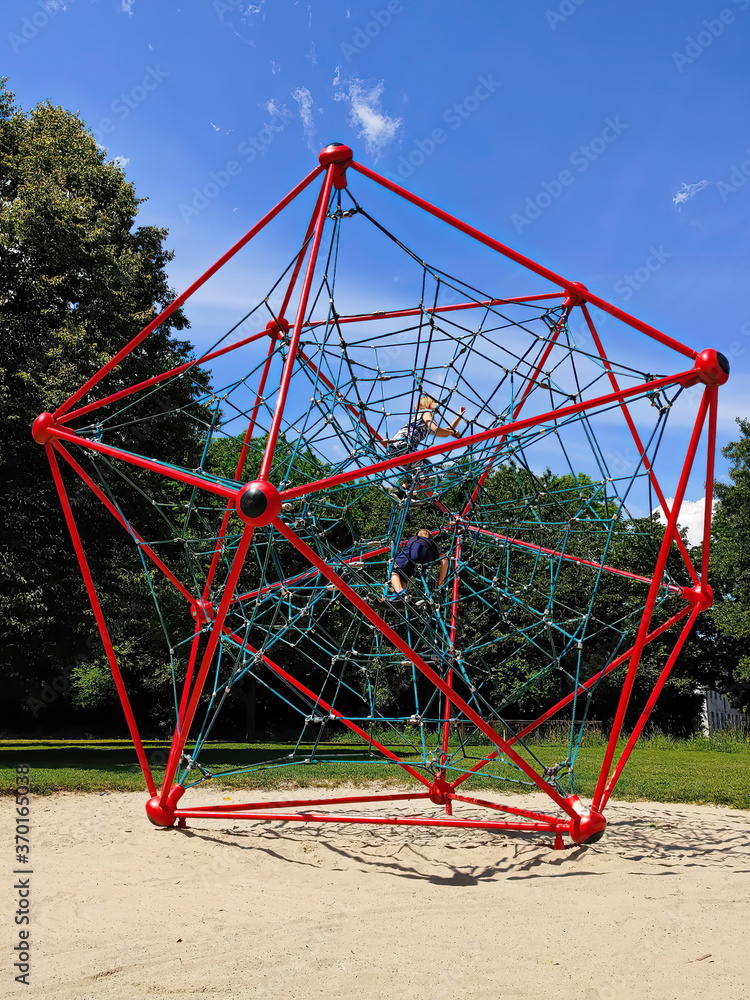 Young boy and girl climbing at gym jungle rope net in children p