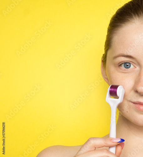 Cosmetology, mesotherapy, skin care. Part of female face with dermaroller on a yellow background. Free space for text.