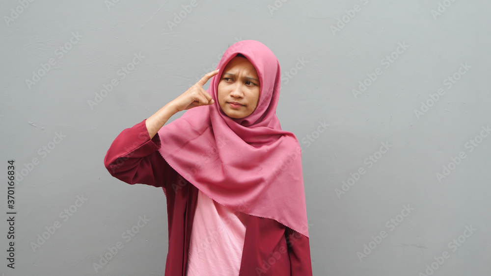 Asian muslim woman wearing hijab with thinking expression. Looking for solution of a problem Asian muslim woman wearing hijab with thinking expression. Looking for solution of a problem