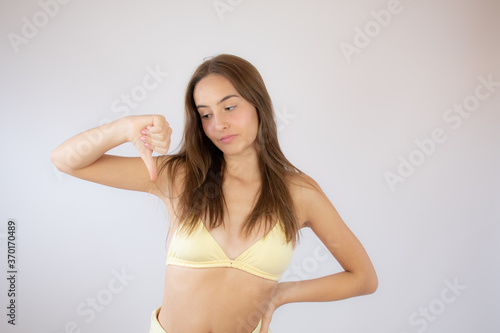 Pretty girl in bikini making the thumb down gesture