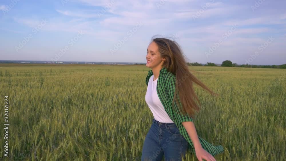 Beautiful teenage girl with long hair in the park. A young girl runs through a wheat field. Happy, free young girl in green wheat. Hair develops in the wind. Beautiful teenage girl with long hair in the park. A young girl runs through a wheat field. Happy, free young girl in green wheat. Hair develops in the wind.