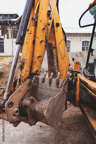 Сonstruction heavy equipment excavator bucket thumb grappler close-up teeth detail photo