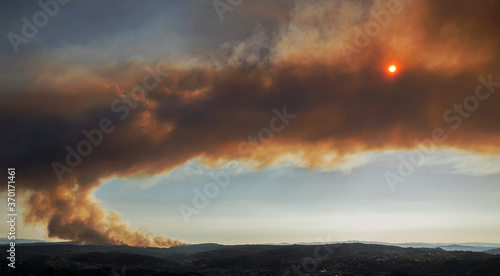 Toen, Ourense, Galicia, España; 08, 07, 2020: A spectacular forest fire in Toen, Ourense, burns 200 hectares and causes a cloud of smoke that eclipses the sun photo