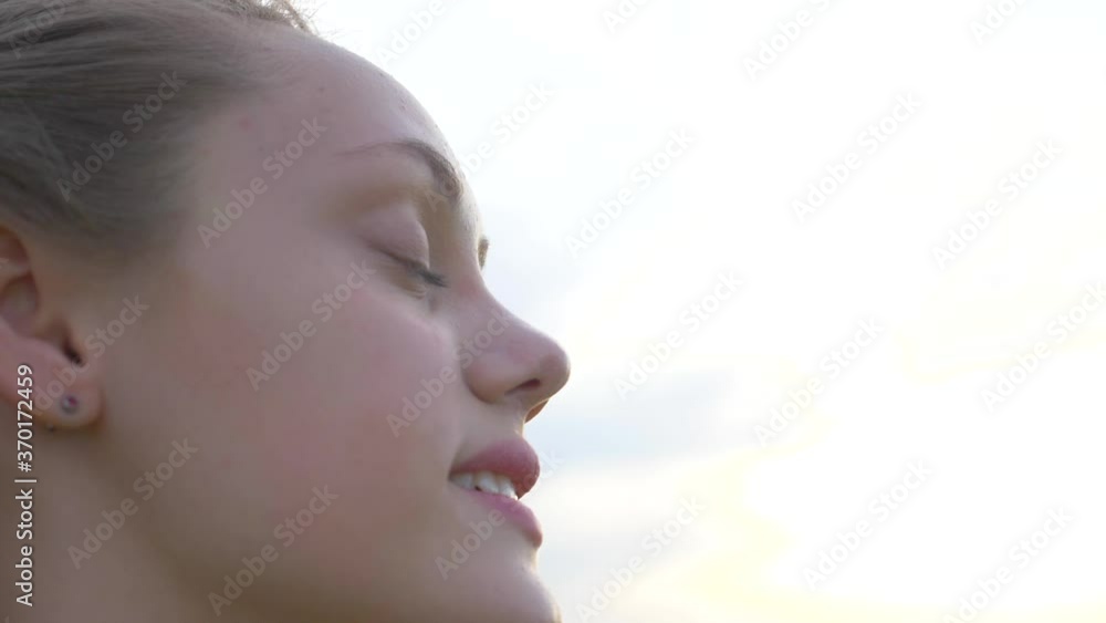 Portrait of a happy young teenager girl on the street. The girl dreams with pleasure with her eyes closed. The lady feels free, successful, ready to start the day, move forward. Portrait of a happy young teenager girl on the street. The girl dreams with pleasure with her eyes closed. The lady feels free, successful, ready to start the day, move forward.