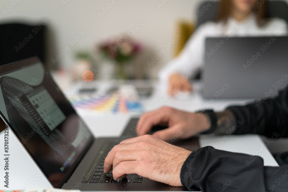 Close-up of male hands using laptop at office, man's hands typing on laptop keyboard in interior. Side view of businessman using computer Close-up of male hands using laptop at office, man's hands typing on laptop keyboard in interior. Side view of businessman using computer