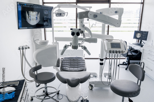 Interior of dental practice room with chair, lamp, display and stomatological tools