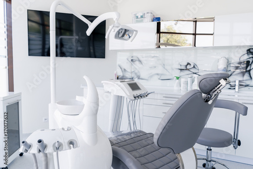 Interior of dental practice room with chair  lamp  display and stomatological tools