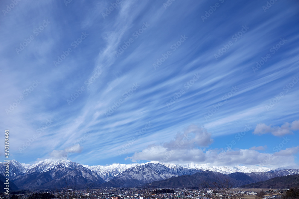 青空にすじ雲（巻雲）がたなびく冬の北アルプス連山 長野県大町市