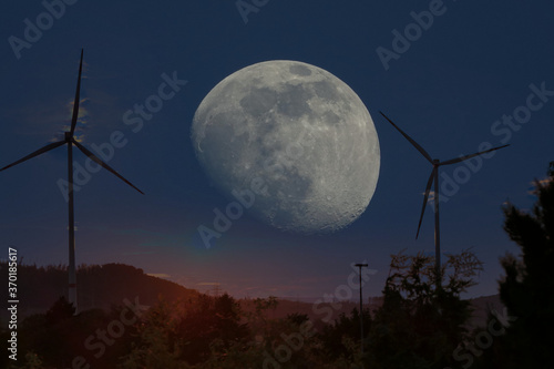 Windräder bei Mondscheinin einer  Landschaft bei klaren Himmel