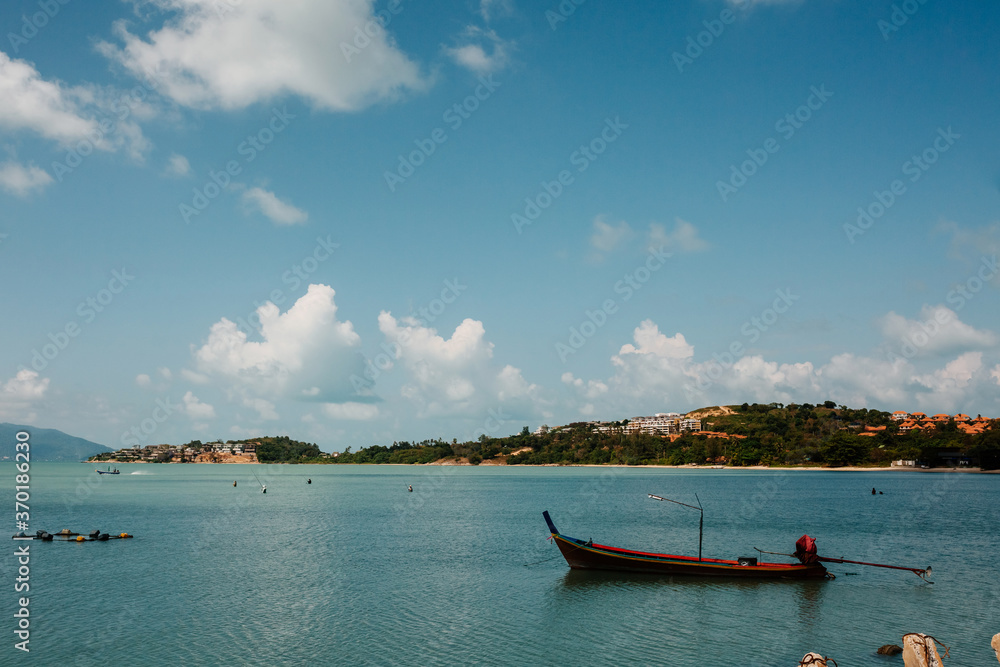 Tropical beach in Thailand with blue ocean, white sand and typical fishermen boat Tropical beach in Thailand with blue ocean, white sand and typical fishermen boat