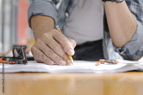 engineer hand is working There are papers placed on the table.