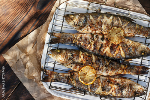 Fotografi Sea Bass fish cooked on coals in a grill