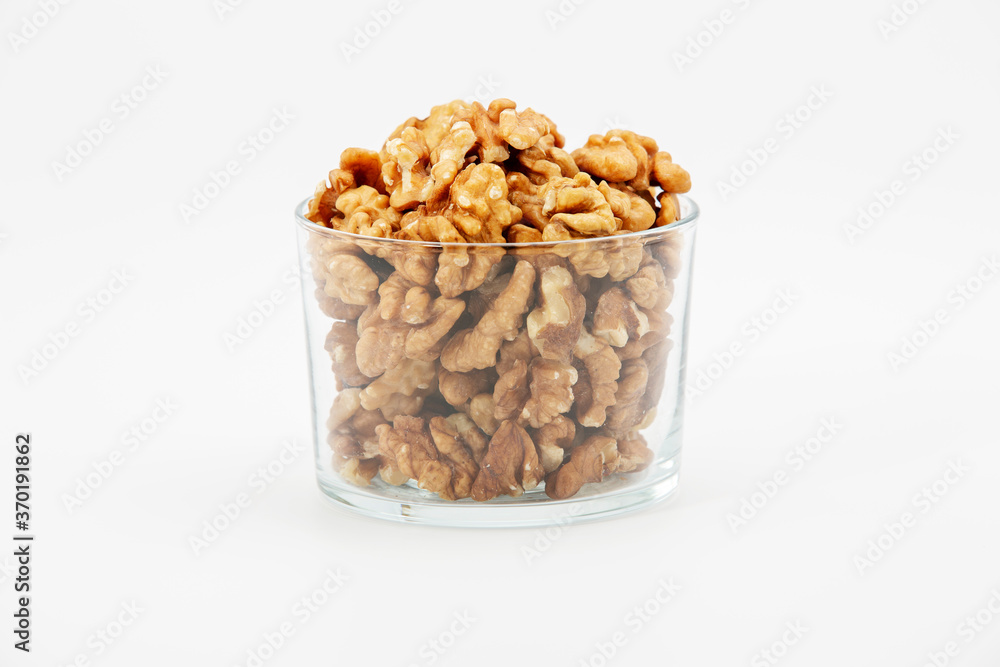 Pile of walnuts in glass bowl on white background. Pile of walnuts in glass bowl on white background.