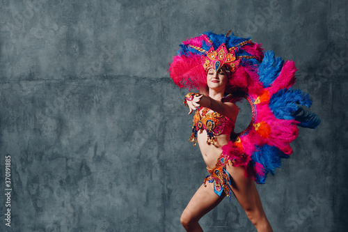 Woman in brazilian samba carnival costume with colorful feathers plumage. photo