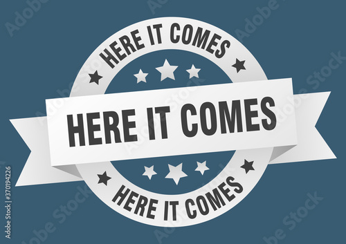 here it comes round ribbon isolated label. here it comes sign