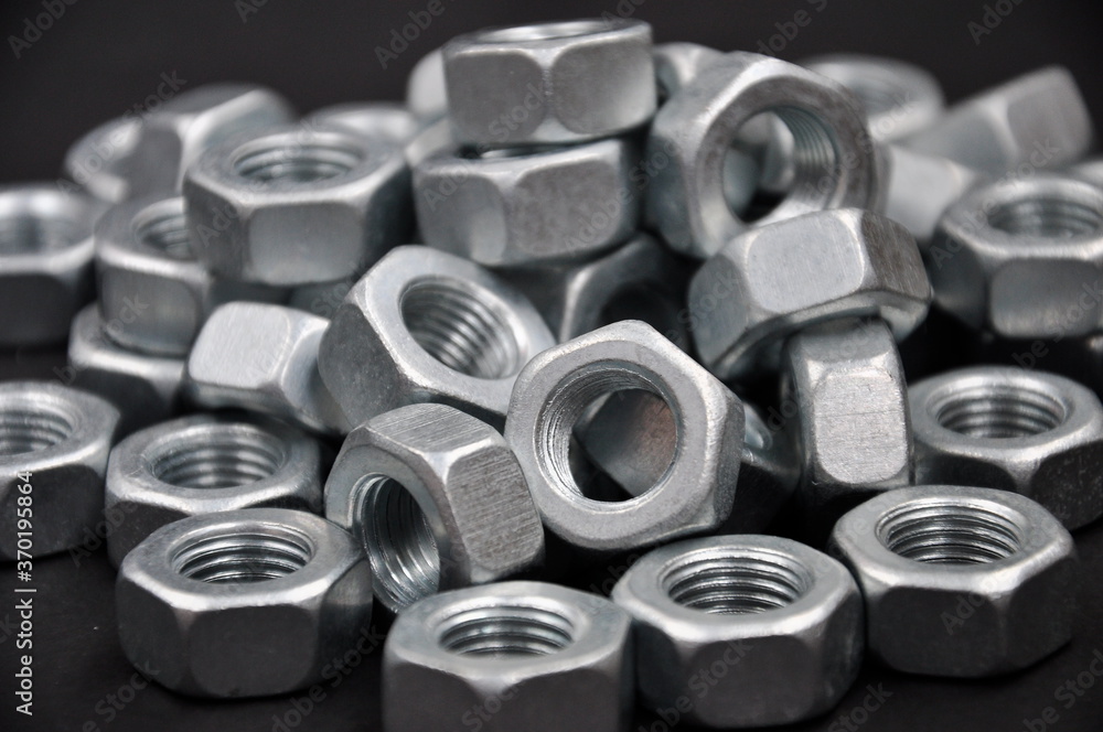 Metal nuts, on a black background. Metal nuts, on a black background.