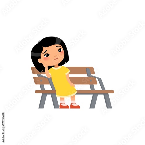 Lonely kid girl is bored in the playground. Sad little asian girl. Unhappy child sitting on bench. Flat vector illustration. Isolated cartoon character on white background.