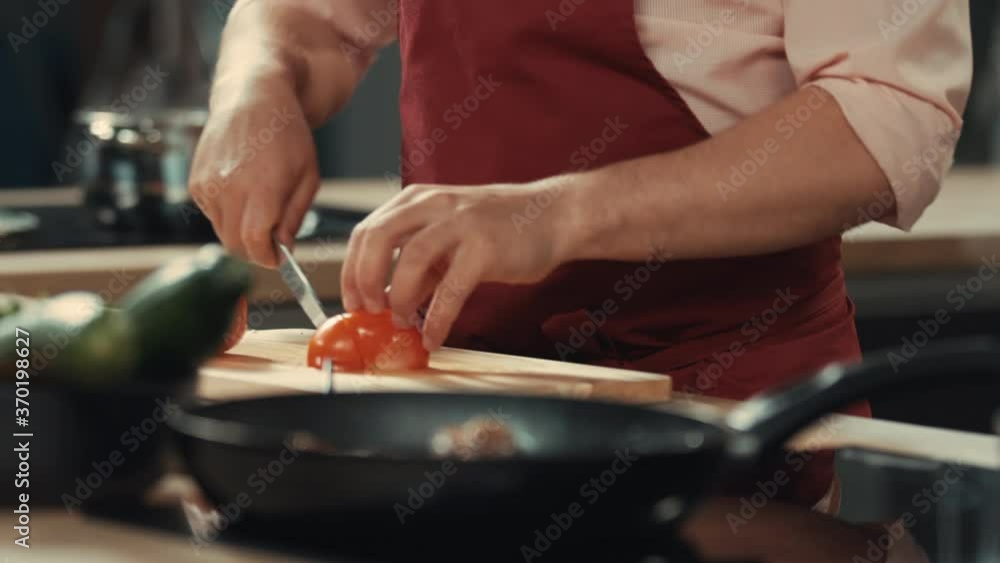 CU Caucasian male chef morning show host cutting tomato on a board CU Caucasian male chef morning show host cutting tomato on a board