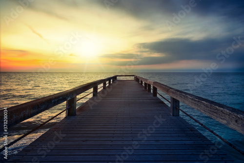 Holzsteg im Meer bei Sonnenuntergang © Tom Bayer