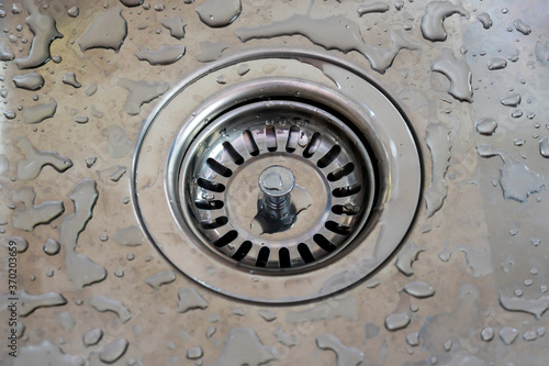 Kitchen sink plug hole closeup with water