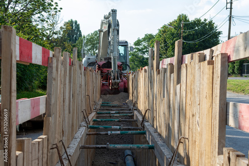 Repair of roads and underground utilities. Big trench on the road with a pipe, the process of repair, or replacing water pipes in a city.